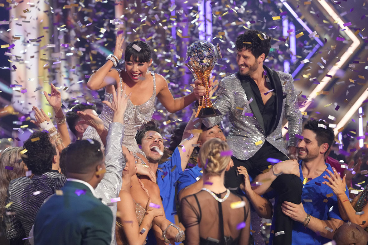 In the Dancing with the Stars finale, several pro dancers lift Len Goodman Mirrorball Trophy winners Xochitl Gomez and Val Chmerkovskiy as confetti flutters around.